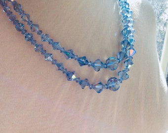 May include: A double strand necklace made of light blue faceted crystal beads.