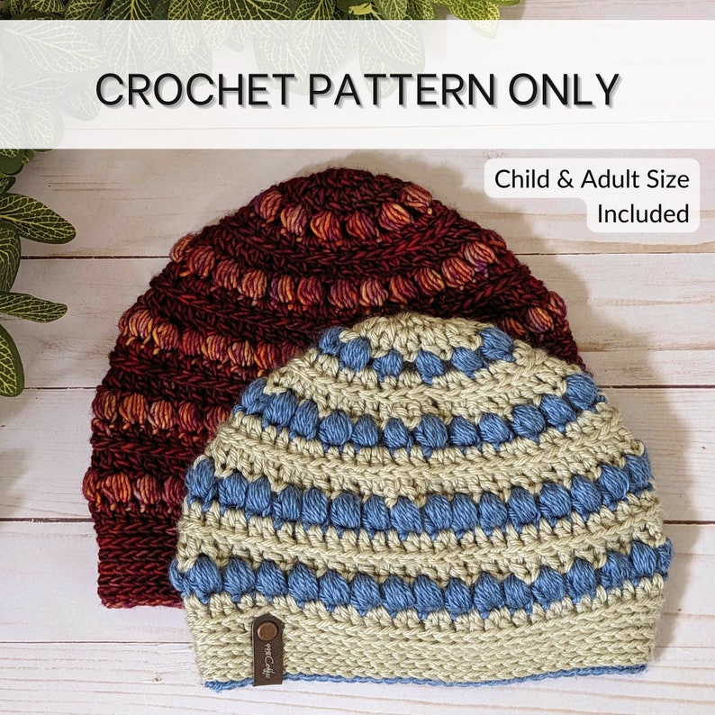 A side-by-side lay of the season's end hat pattern is shown with a child and adult sized hat. They are shown on a white wood slat backdrop with faux vines over the top of the image.