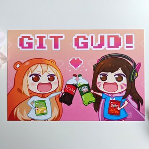 May include: A pink and orange illustrated card with two cartoon characters holding a can of cola and a green can of soda. The text "GIT GUD!" is in pixelated letters at the top of the card.