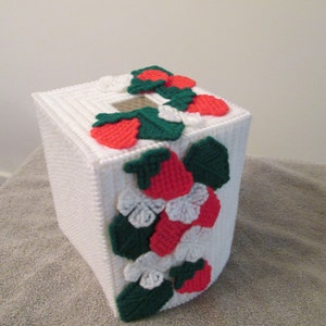 Pode incluir: Capa de caixa de lenços de papel branco de plástico com um design de morango vermelho e verde. A capa é decorada com morangos vermelhos, folhas verdes e flores brancas.