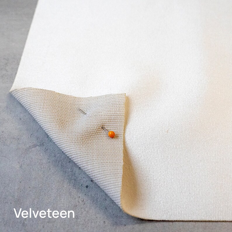 Pu&ograve; includere: Primo piano di un tessuto vellutato bianco con un retro beige. Il tessuto &egrave; fissato con due spilli.