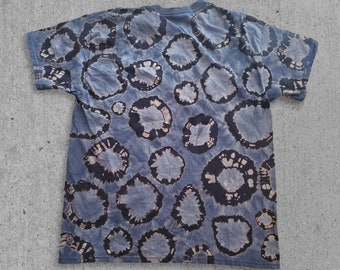 Könnte beinhalten: Ein blaues Batik-T-Shirt mit einem kreisförmigen Muster.