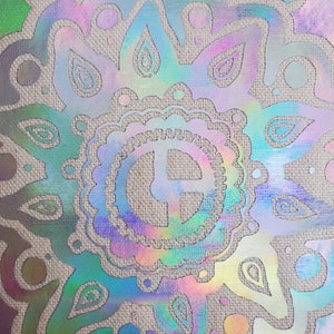 May include: A colorful, iridescent mandala design with a central circle containing the letter "E" on a textured, beige background.