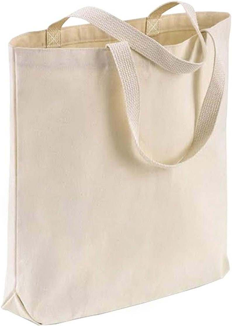 May include: A plain white canvas tote bag with two long, cream-colored straps.
