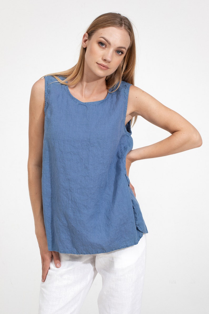 May include: A sleeveless linen top in a light blue color. The top has a round neckline and a relaxed fit.