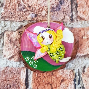 Hand crafted hand painted wood slice wall hanging. Polymer clay fairy.