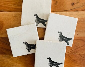 May include: Set of four white marble coasters with black ink illustrations of a dog breed. Each coaster features a different pose of the dog.