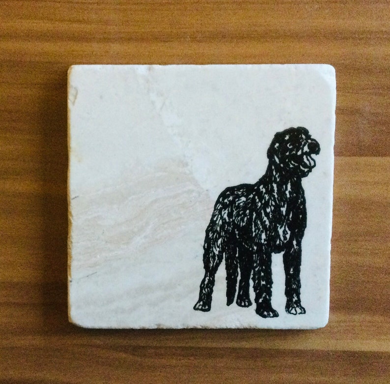 May include: A black and white silhouette of a dog on a white square coaster.