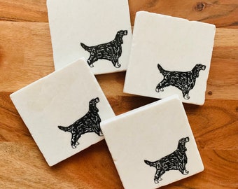 May include: Four white square coasters with black silhouettes of a dog breed. The coasters are made of marble and have a smooth, polished surface.