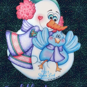 Könnte beinhalten: Ein handbemalter Schneemann mit einem rosa Hut und einem lila Schal, der einen blauen Vogel mit einer lila Schleife hält. Der Schneemann hat eine Karottennase und ein Herz auf der Wange. Der Hintergrund ist dunkelgrün mit weißen Schneeflocken. Der Text "Cecil the Snowman" befindet sich am unteren Rand des Bildes.