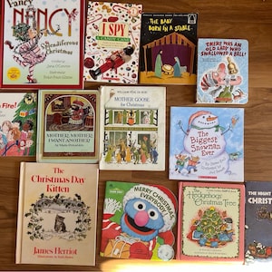 May include: A collection of children's Christmas-themed books, including titles like "Fancy Nancy: Splendiferous Christmas," "The Biggest Snowman Ever," and "The Night Before Christmas." The books feature colorful illustrations and festive designs.