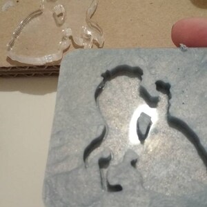 Könnte beinhalten: Eine graue Silikonform mit einem Ausschnitt von zwei Personen, die sich an den Händen halten. Die Form ist zum Herstellen von Kunsthandwerk aus Harz gedacht.