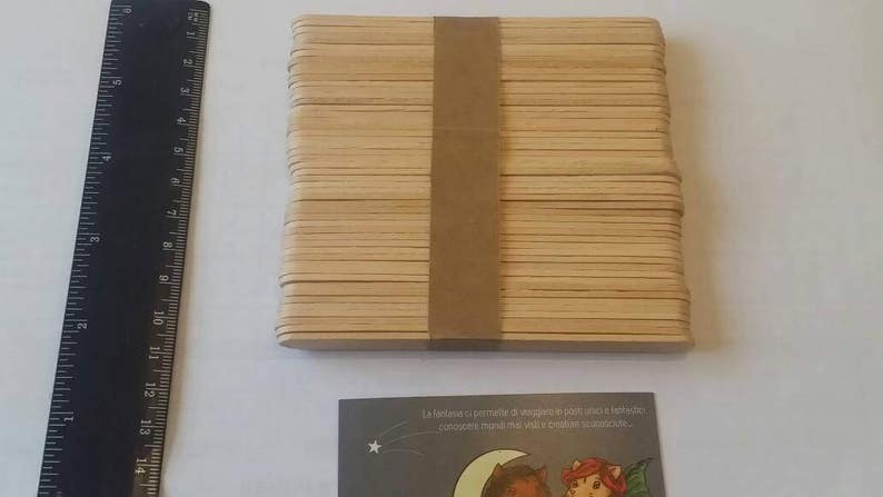 K&ouml;nnte beinhalten: Ein Stapel aus 50 nat&uuml;rlichen Holz-Bastelst&auml;bchen, zusammengebunden mit braunem Klebeband. Die St&auml;bchen sind etwa 11,5 cm lang und 1,5 cm breit.