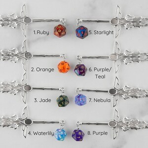 May include: Eight silver sword hair sticks with different colored dice charms. The hair sticks are arranged in four rows of two. The dice charms are labeled with numbers 1 through 8. The dice charms are: 1. Ruby, 2. Orange, 3. Jade, 4. Waterlily, 5. Starlight, 6. Purple/Teal, 7. Nebula, 8. Purple.