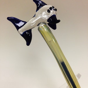 Könnte beinhalten: Eine Glaspfeife mit einem blauen und weißen Fischdesign. Die Pfeife ist klar und hat einen gelben Schaft.