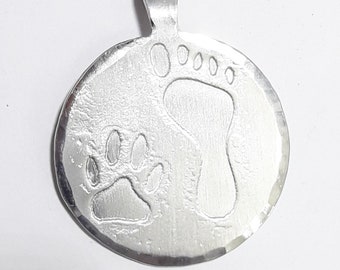 Aluminum pendant medal with a dog paw print and human footprint, with personalized text on the back.