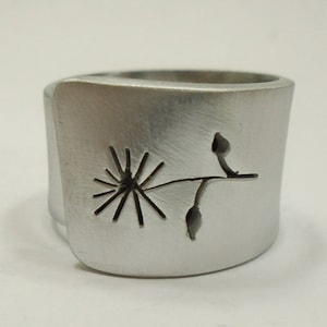 Adjustable aluminum band ring with a flower and 2 perforated leaves , and custom text.