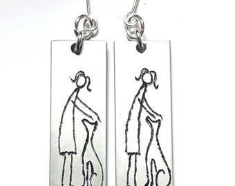 Personalized text, anodized aluminum earrings, engraved with primitive designs of her and the dog.