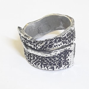 Open band ring in aluminum with blackened check patterns and hammered polished edge, and personalized text.