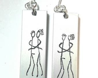 Personalized text anodized aluminum light earrings, engraved with primitive designs of she and him in hug.