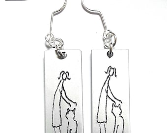 Personalized text, anodized aluminum light earrings, engraved with primitive designs of her and the cat.