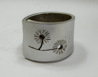 Open aluminum band ring with two perforated (pierced) flowers, and custom text.