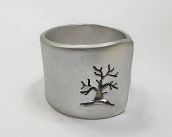 Open aluminum band ring with perforated tree perpendicular to the ring, and custom text.