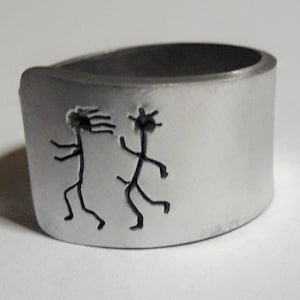 Open aluminum band ring with: He follows her, and custom text.