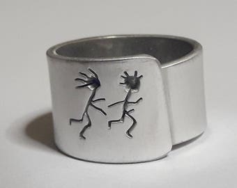 Open aluminum band ring with: She follows him, and custom text.