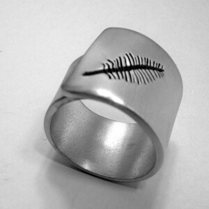 Personalized text, open aluminum band ring with a perforated feather.