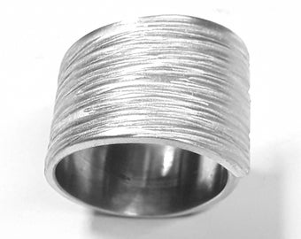 Open aluminum ring handmade forged with lines texture and personalized text.