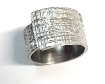Open aluminum ring handmade forged with juta texture and personalized text.