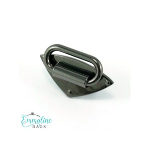 May include: A black metal handle with a diamond-shaped base. The handle is designed for attaching to bags or purses.
