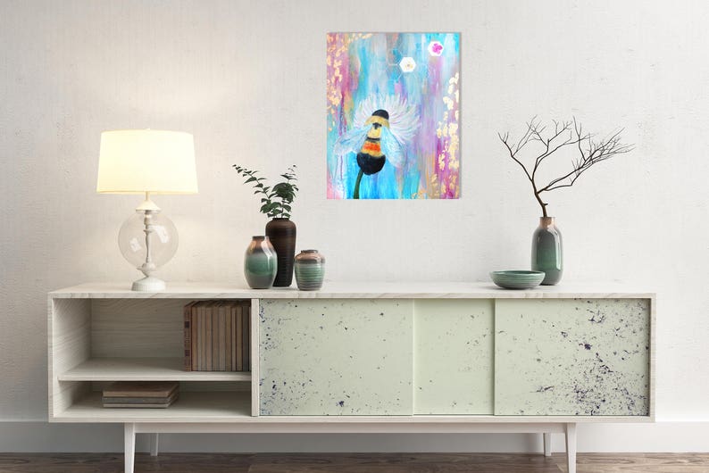 May include: A painting of a bumblebee with a white fuzzy body and black and yellow stripes, flying in front of a blue and pink flower. The background is a light blue and pink abstract design.