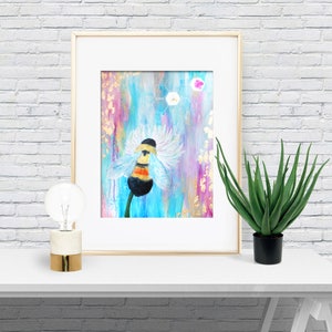 May include: A framed painting of a bumblebee on a flower with a blue, pink, and gold background. The bee is yellow and black with white wings. The flower is white with a yellow center. The background has a geometric pattern of hexagons.