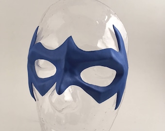 Peut inclure: Un masque de super-héros bleu avec un design pointu. Le masque est fait d'un matériau souple et flexible et possède des trous pour les yeux pour la visibilité.