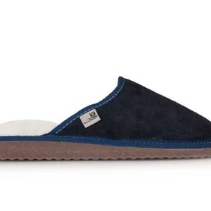 May include: Navy blue suede slippers with a white fleece lining and a brown rubber sole.