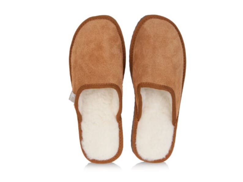 May include: A pair of brown suede slippers with a white sheepskin lining. The slippers have a closed toe and a slip-on design.