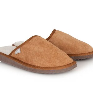May include: A pair of brown suede slippers with a white fleece lining. The slippers have a closed toe and a slip-on design.