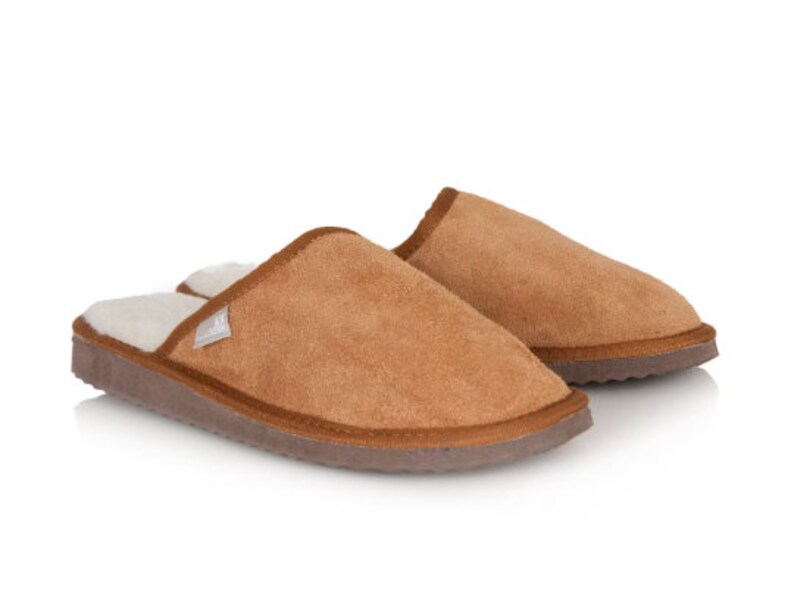 May include: A pair of brown suede slippers with a white fleece lining. The slippers have a closed toe and a slip-on design.