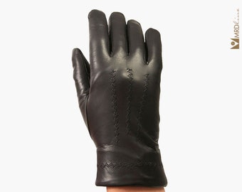 May include: Black leather gloves with a decorative stitched pattern on the back of the hand.