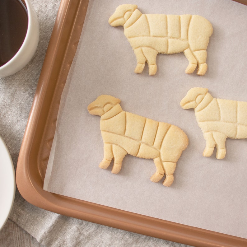 Peut inclure: Trois biscuits sabl&eacute;s en forme de mouton sur une plaque &agrave; p&acirc;tisserie recouverte de papier sulfuris&eacute;.