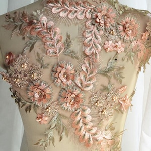 May include: Peach and gold floral applique with pearl embellishments. This delicate lace trim is perfect for adding a touch of elegance to any garment.