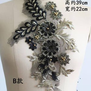 May include: Black and gold floral applique with beaded accents. The applique measures approximately 39 inches tall and 22 inches wide.