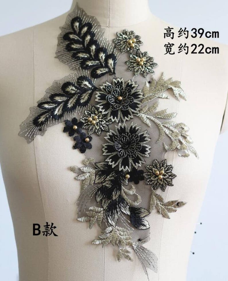 May include: Black and gold floral applique with beaded accents. The applique measures approximately 39 inches tall and 22 inches wide.
