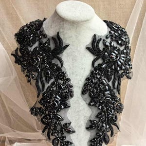 May include: Black beaded lace trim with floral designs. The trim is made of black beads and sequins and is perfect for adding a touch of elegance to any garment.