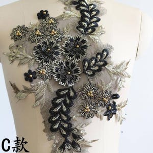 May include: Black and gold floral lace applique with beaded accents. The applique measures approximately 17.7 inches tall and 10.6 inches wide.