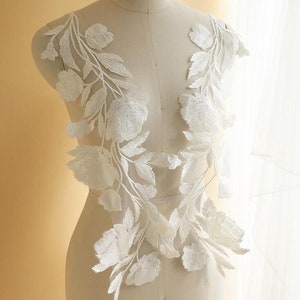 Puede incluir: Dos aplicaciones de encaje floral blanco con delicadas hojas y flores. Las aplicaciones son perfectas para agregar un toque de elegancia a los vestidos de novia, los accesorios de novia u otros proyectos de manualidades.