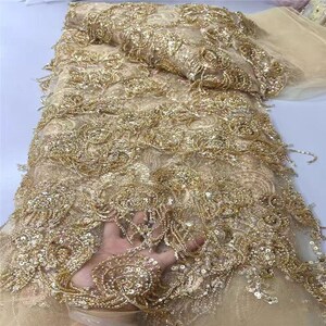 May include: Gold embroidered lace fabric with intricate floral patterns and shimmering sequins. The fabric has a delicate, sheer base and is densely decorated with raised embroidery and beadwork, creating a luxurious texture.
