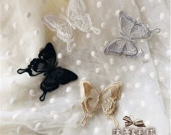 May include: Four embroidered butterfly patches in different colors and designs. The patches are on a white fabric with small white dots.
